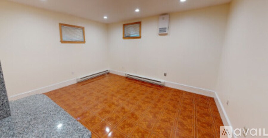 A room with wooden flooring and two picture frames on the wall.