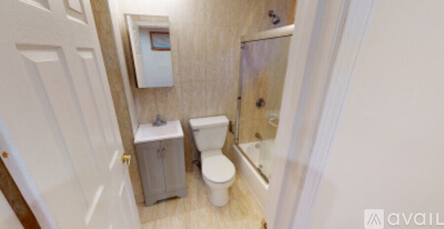 A small bathroom with a toilet and a cabinet.