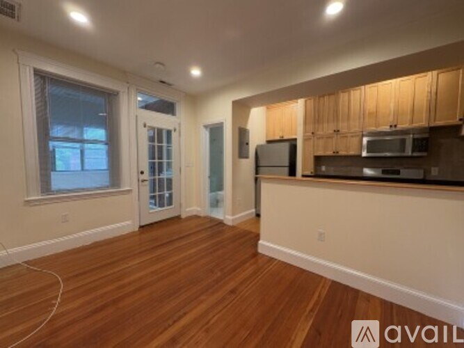 A kitchen with wooden floors and a countertop with a microwave and oven.