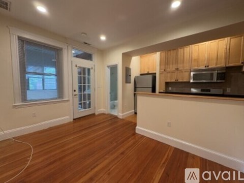 A kitchen with wooden floors and a countertop with a microwave and oven.