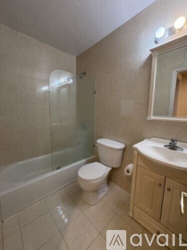 A bathroom with a toilet, sink, and bathtub.