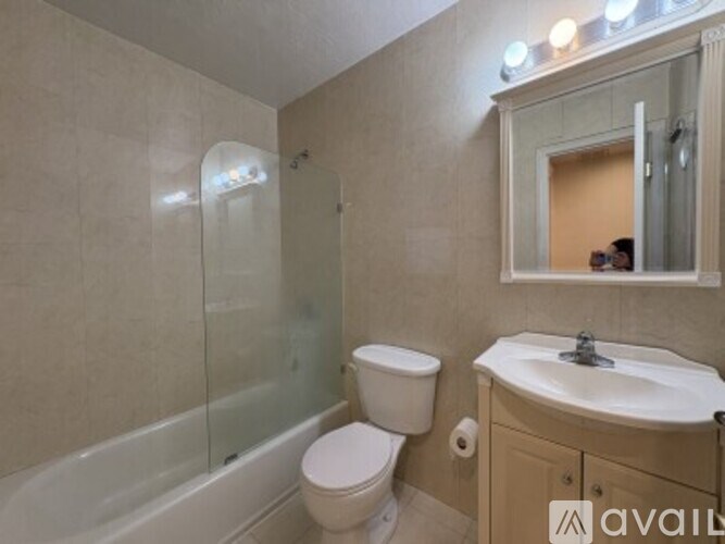 A bathroom with a toilet, sink, and shower.