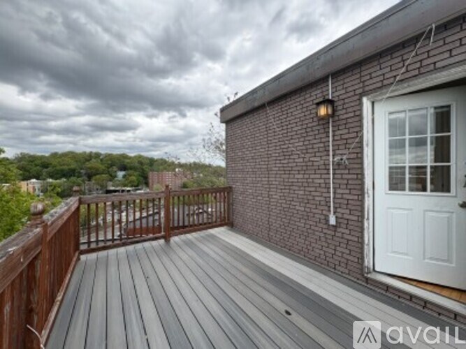 A wooden deck with a white door and a cloudy sky in the background.