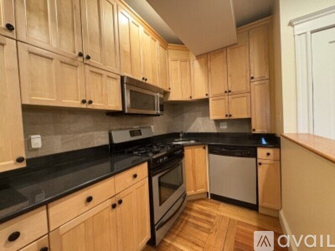 A kitchen with wooden cabinets and black countertops.