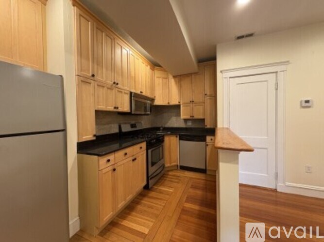 A kitchen with wooden cabinets and a refrigerator.