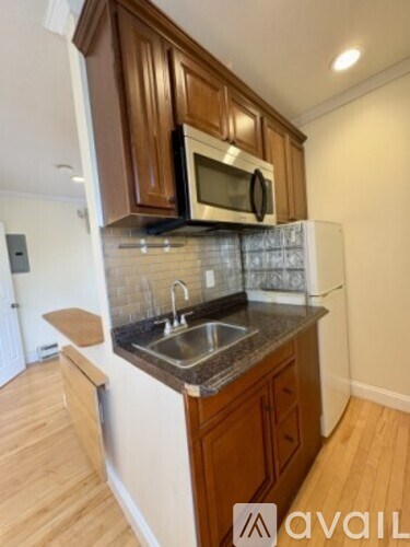 A kitchen with wooden cabinets and a stainless steel sink.