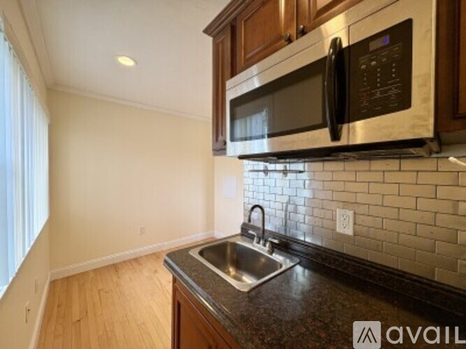 A kitchen with a stainless steel microwave above a sink.
