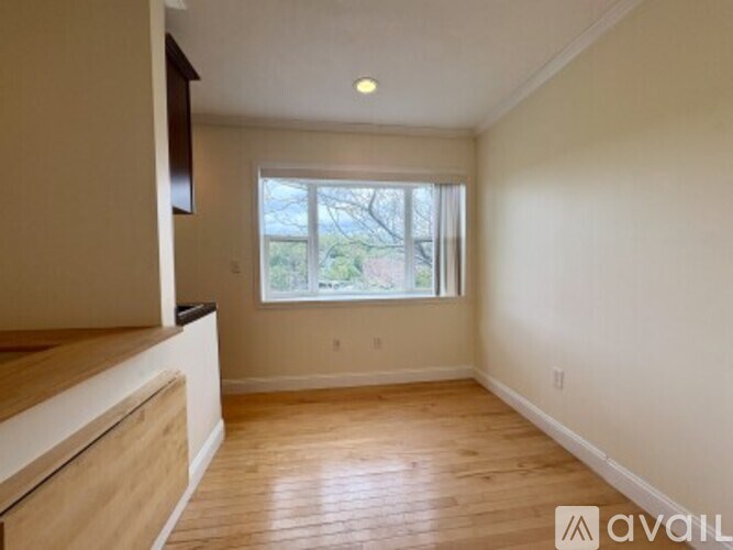 A room with wooden floors and a window with blinds.