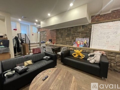 A living room with black leather couches and a wooden coffee table.