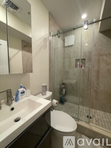 A bathroom with a toilet, sink, and shower.