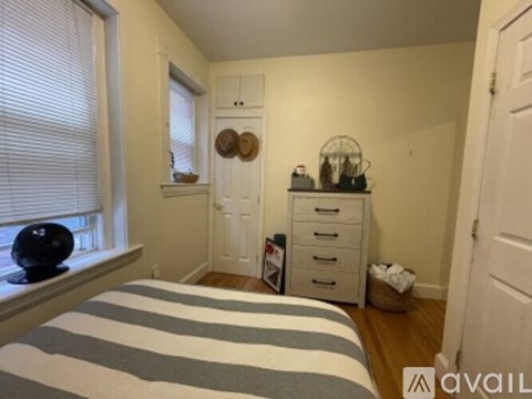 A bedroom with a bed, dresser, and window.