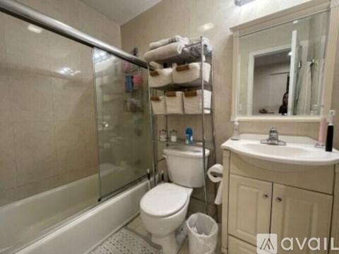 A bathroom with a toilet, sink, and shower.