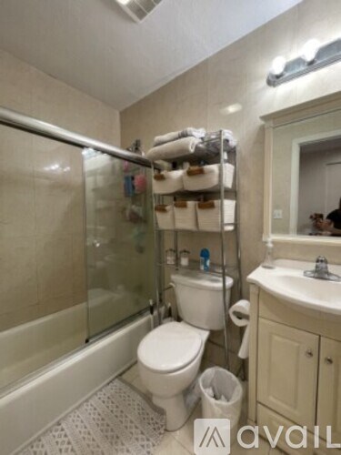 A bathroom with a toilet, sink, and a shower with a glass door.