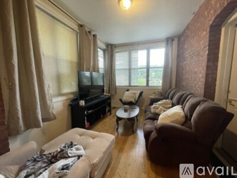 A living room with a couch, chair, and television.