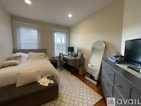 A bedroom with a large bed and a desk with a computer.