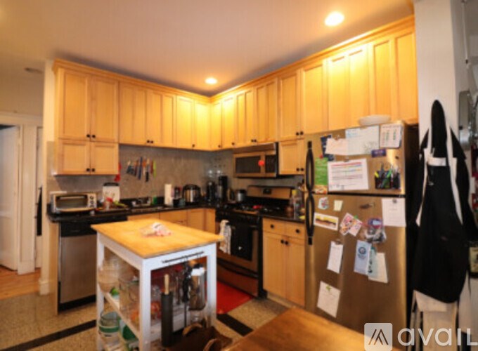 A kitchen with wooden cabinets and a refrigerator with magnets on it.