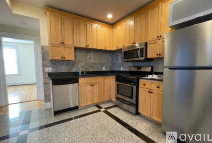 A kitchen with wooden cabinets and a black counter top.