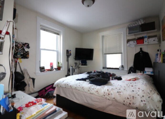 A small bedroom with a bed in the center and a window on the left wall.