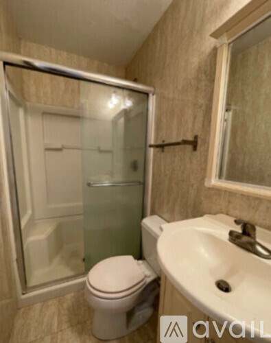 A bathroom with a toilet, sink, and shower.