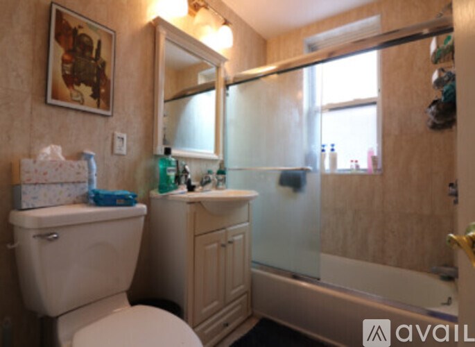 A bathroom with a toilet, sink, and mirror.