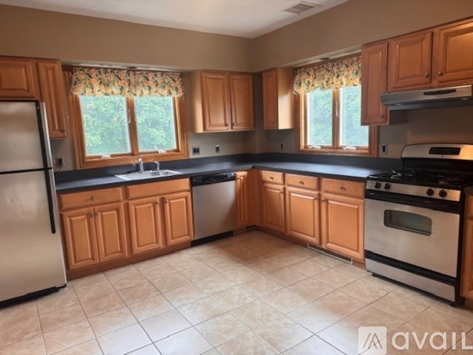 A kitchen with wooden cabinets and a black countertop.