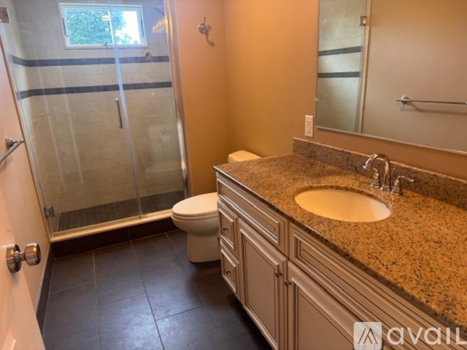 A bathroom with a sink, toilet, and shower.