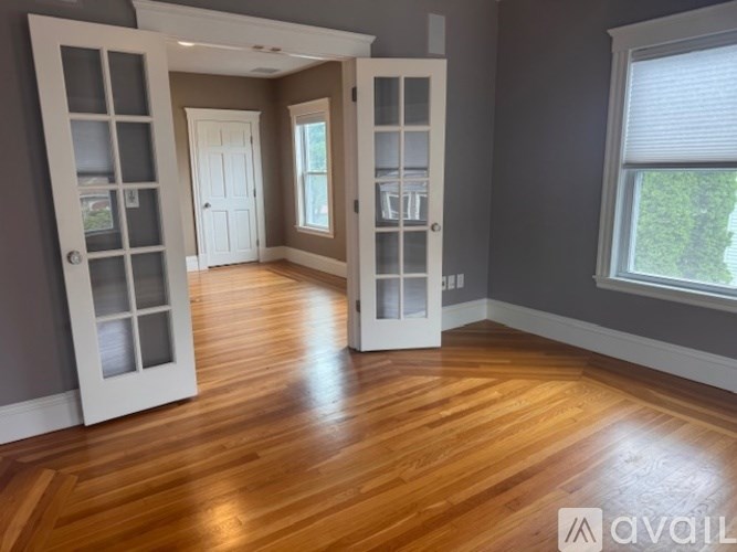 A room with wooden floors and white doors.