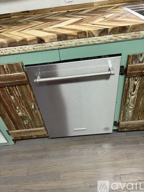 A white dishwasher is placed in a kitchen with wooden cabinets.