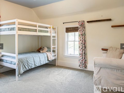 A bedroom with a bunk bed and a couch.