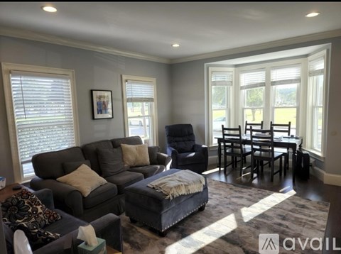 A living room with a grey couch and a black chair.