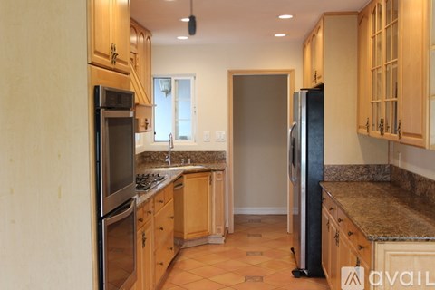 A kitchen with wooden cabinets and granite countertops.