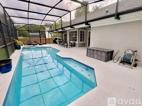 A pool with a glass enclosure and a bench outside.