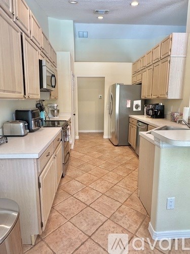 A kitchen with wooden cabinets and a tile floor.