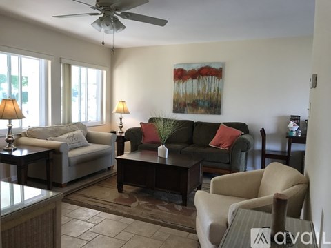 A living room with a couch, chair, and a painting on the wall.