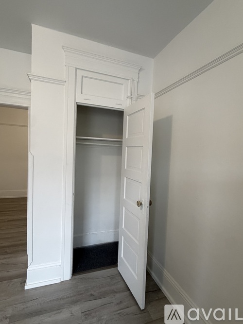 A white door is open to a small, empty room.