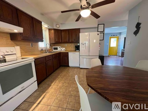 A kitchen with brown cabinets and a white stove top oven.