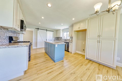 A kitchen with wooden floors and white walls.