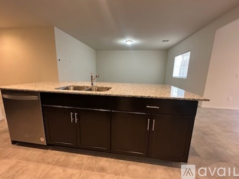 A kitchen with black cabinets and a granite countertop.