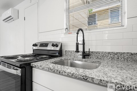 A kitchen with a granite countertop and a stove top oven.