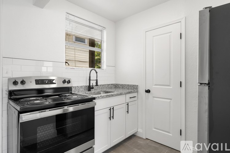 A kitchen with white cabinets and a black stove top oven.