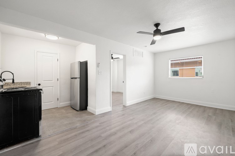 A spacious room with a ceiling fan and a large window.