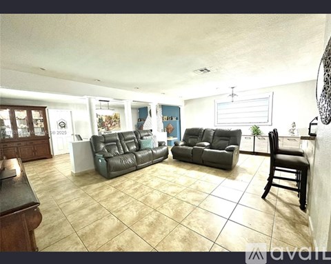 A living room with a leather couch and a wooden table.
