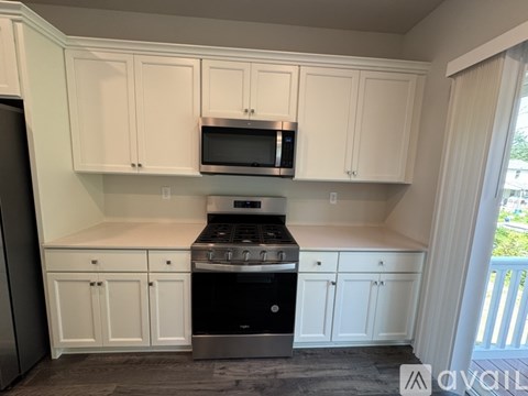 A kitchen with white cabinets and a black stove top oven.