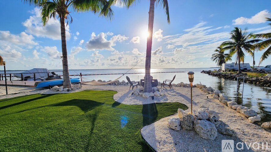 A sunny day at the beach with palm trees and a clear blue sky.