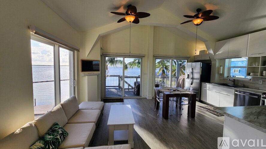 A living room with a couch, a table, and a ceiling fan.