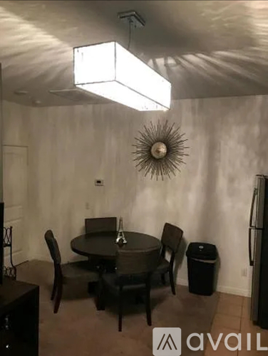 A dining room with a table and chairs.