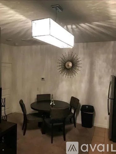 A dining room with a table and chairs.