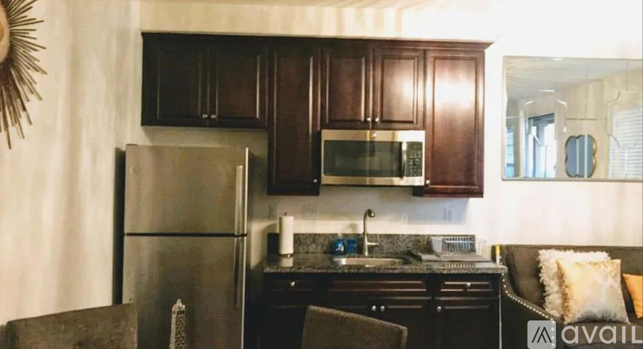 A kitchen with dark brown cabinets and a stainless steel refrigerator.