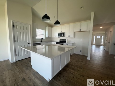 A kitchen with white cabinets and a large island.
