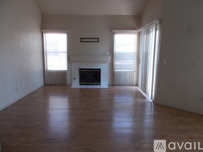 A living room with a fireplace and sliding glass doors.